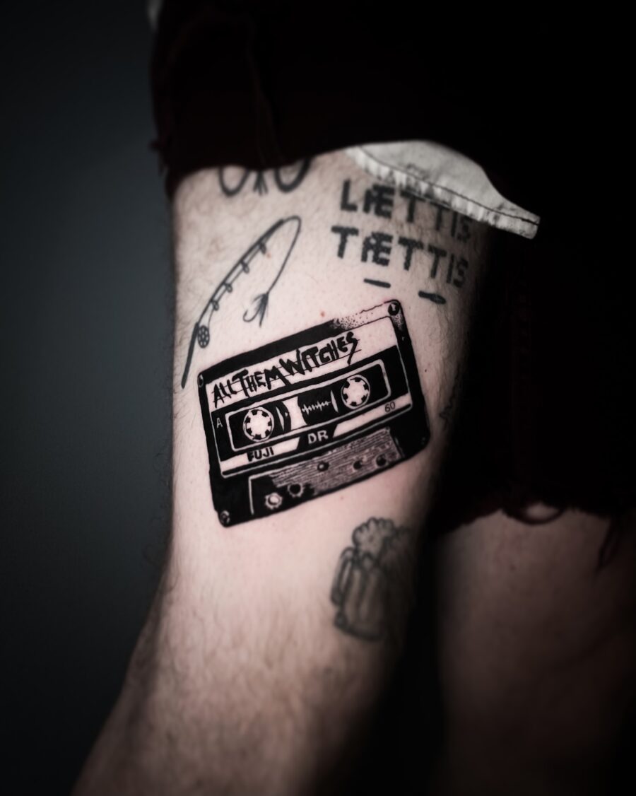 This tattoo showcases a vintage cassette tape, capturing nostalgia with its classic design.