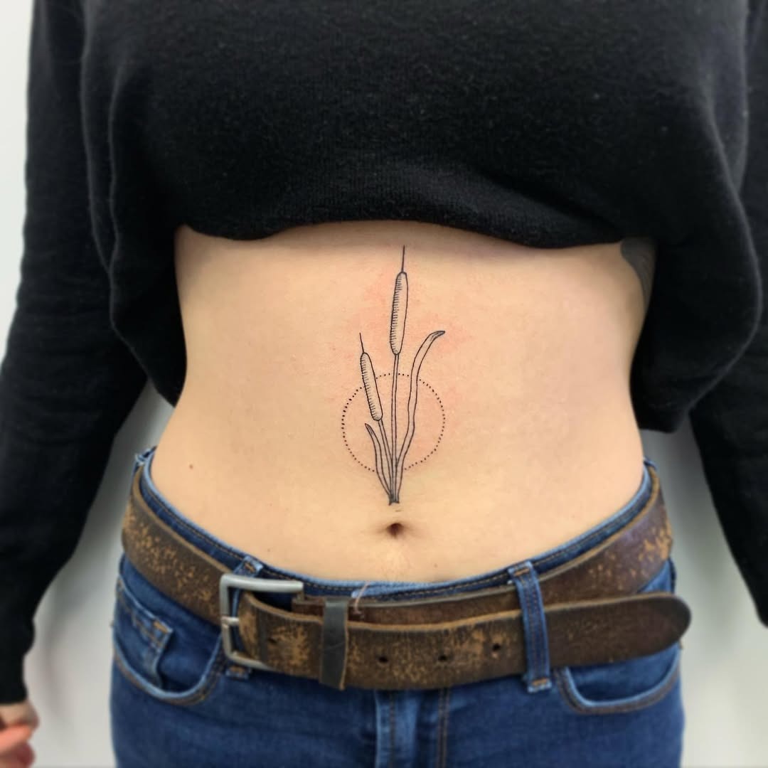 This cattail tattoo showcases a beautiful minimalist design located on the belly.