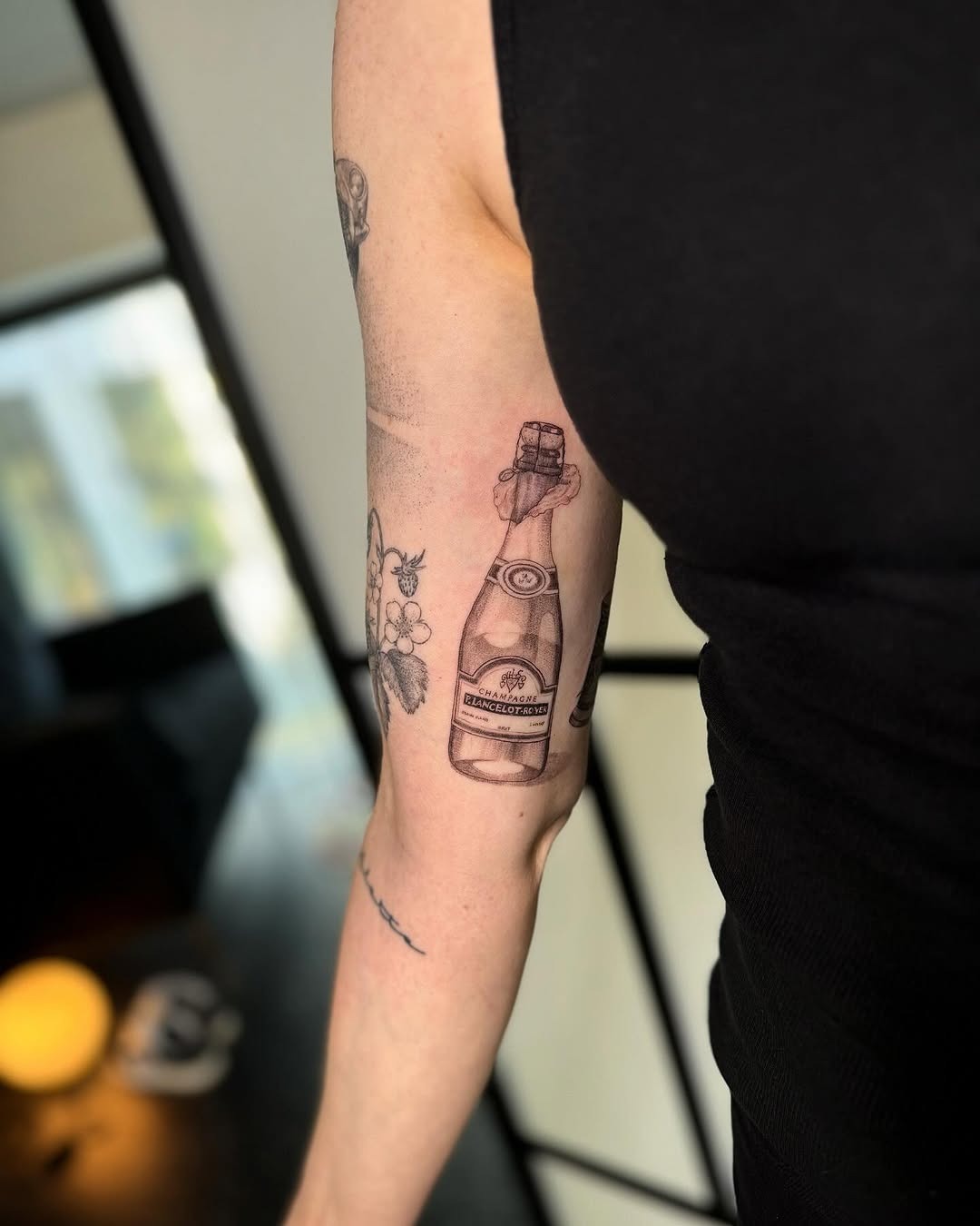 Elegant champagne tattoo with floral accents Tattoo Design