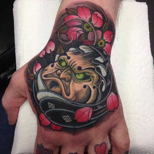 The Angry Face Surrounded by Flowers Tattoo Design