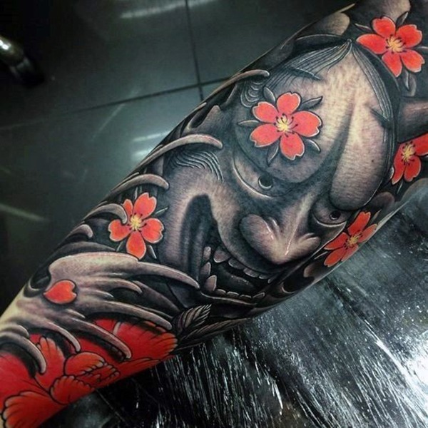 The Strange Face Surrounded by Cherry Blossom Flowers Tattoo Design