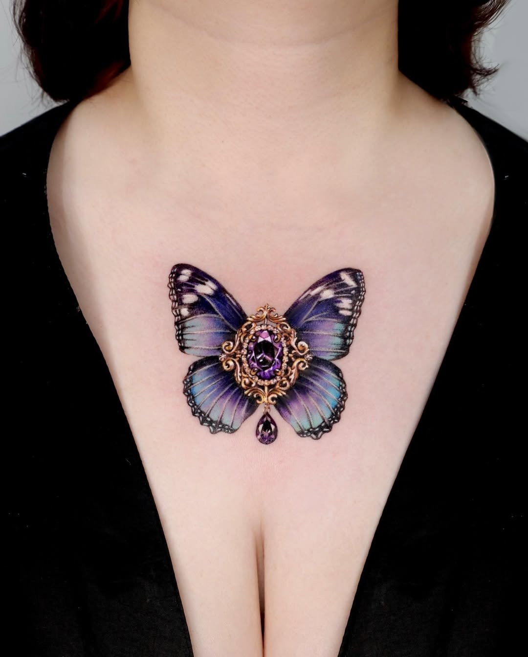 Elegant butterfly chest tattoo with gemstone details Tattoo Design