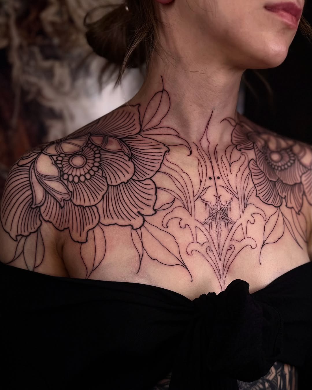 Elegant floral chest tattoo with bold outlines Tattoo Design