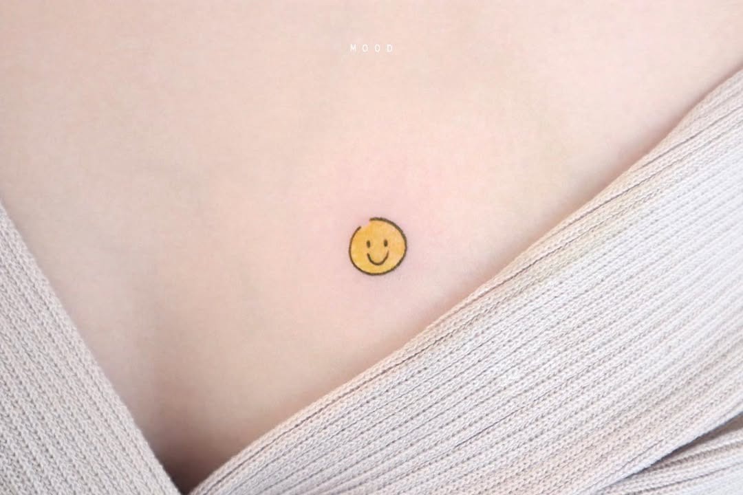 Minimalist smiley face chest tattoo design Tattoo Design
