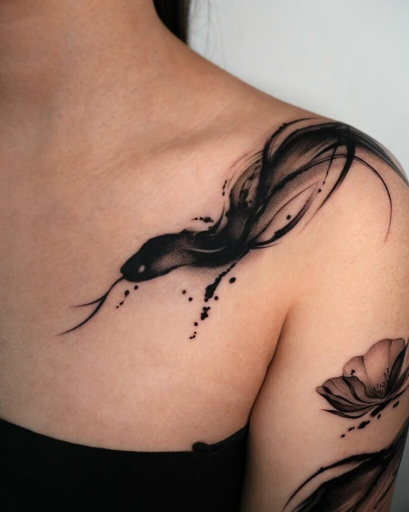 This mesmerizing collarbone tattoo features an abstract snake design crafted in bold black ink.