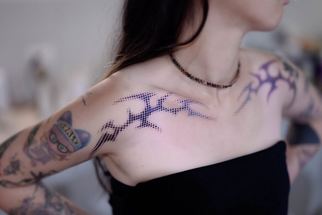 A striking abstract tattoo design gracing the collarbone area, featuring a captivating pattern of interconnected dots that form bold, geometric shapes.