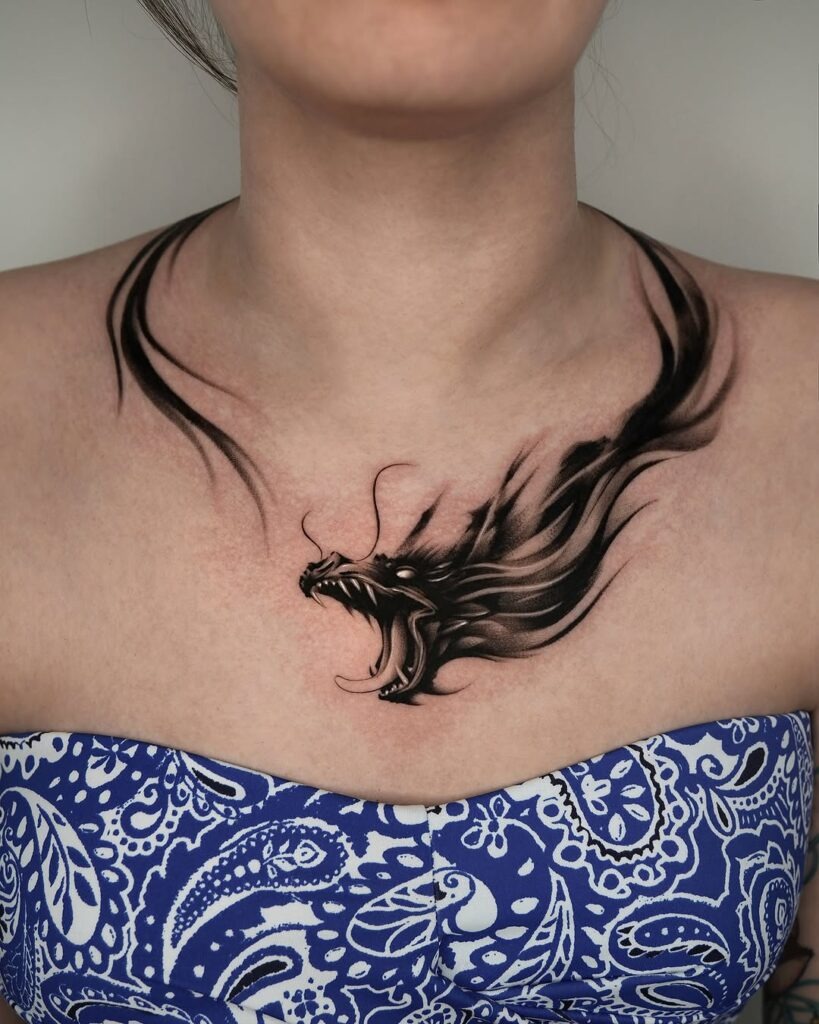 This tattoo captures the fiery essence of a roaring dragon, its dynamic flow and powerful presence perfectly accentuating the collarbone.