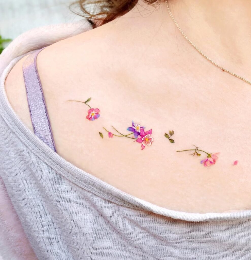 A charming tattoo of wildflowers scattered delicately along the collarbone.