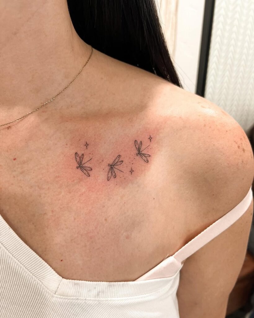This charming collarbone tattoo captures the grace of dragonflies in a minimalist design.