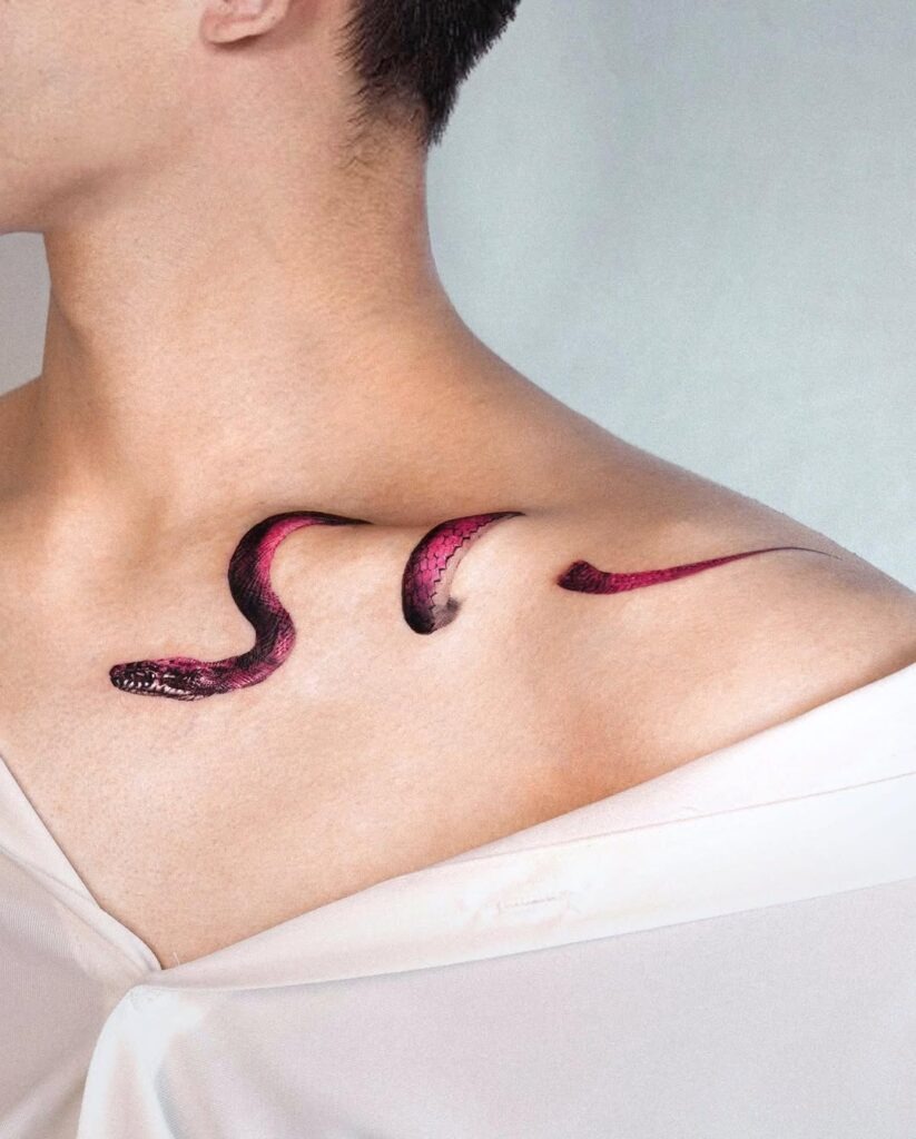 A striking red snake tattoo elegantly slithering across the collarbone, featuring bold colors and detailed scales.