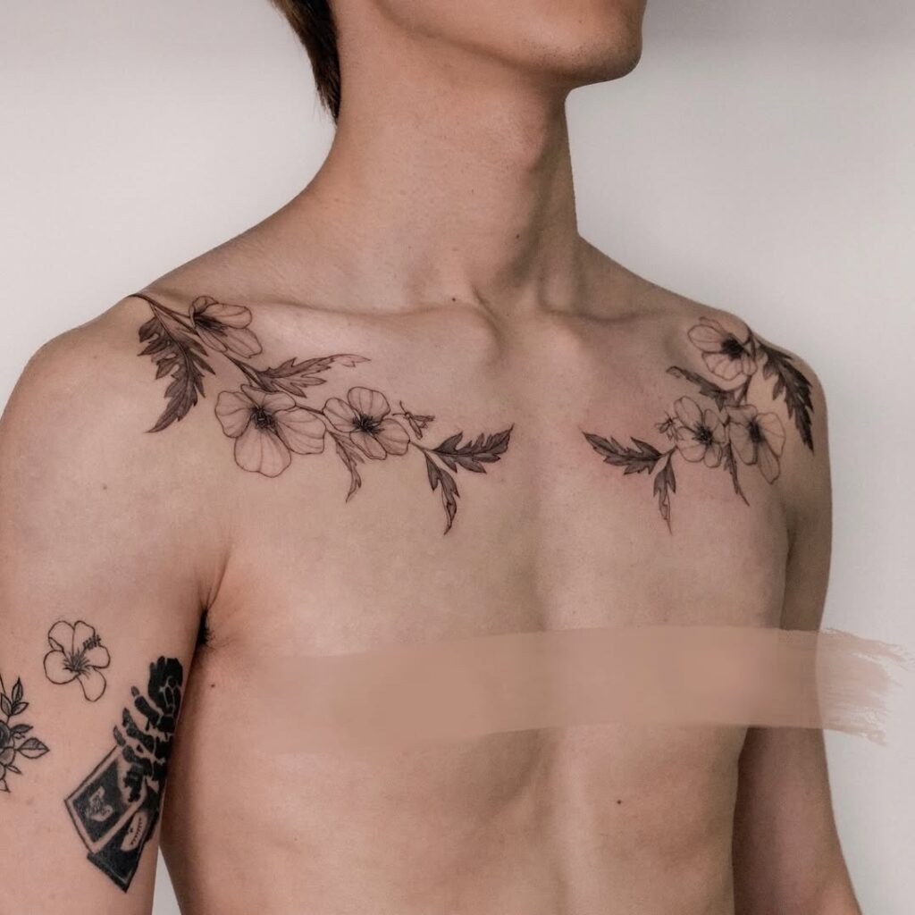 This tattoo design features symmetrical floral arrangements across the collarbones, combining natural elegance with bold artistry.