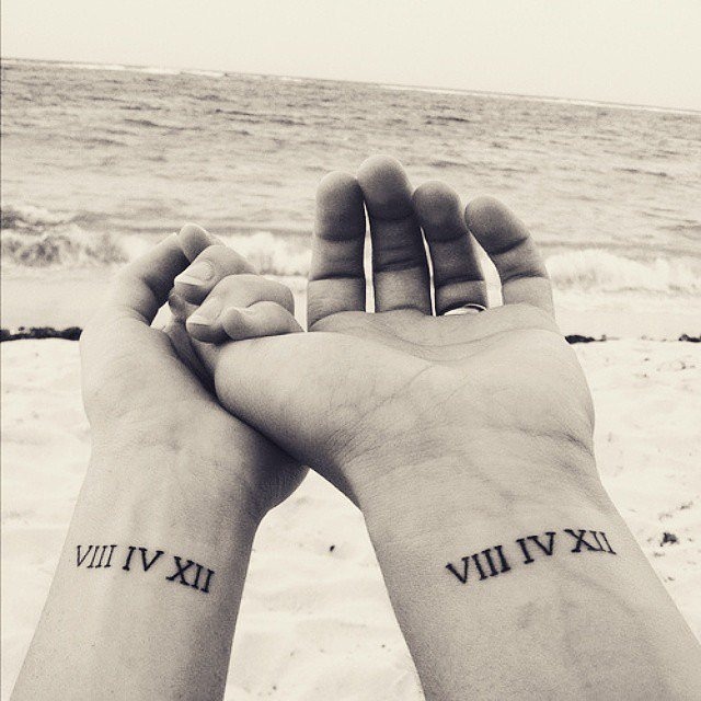 This tattoo design features a crown on each partner's wrist, symbolizing their roles as king and queen in each other's lives.