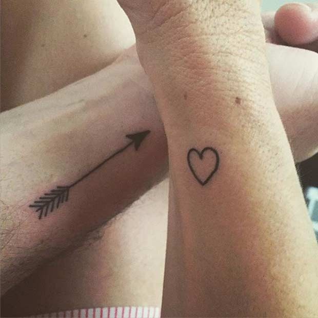 In this design, one partner has an arrow tattooed on their wrist, while the other has a heart.