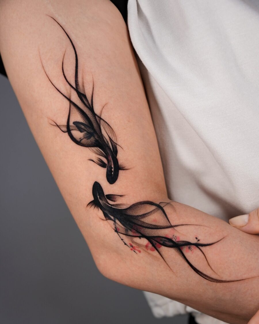 Graceful black fish tattoos with floral accents Tattoo Design