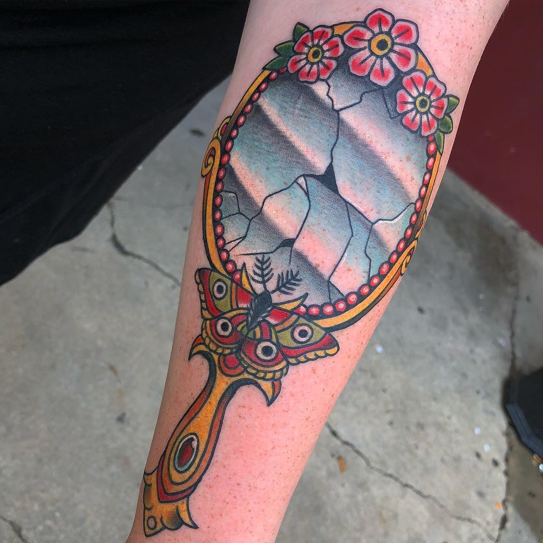 Unique cracked mirror tattoo with floral accents Tattoo Design