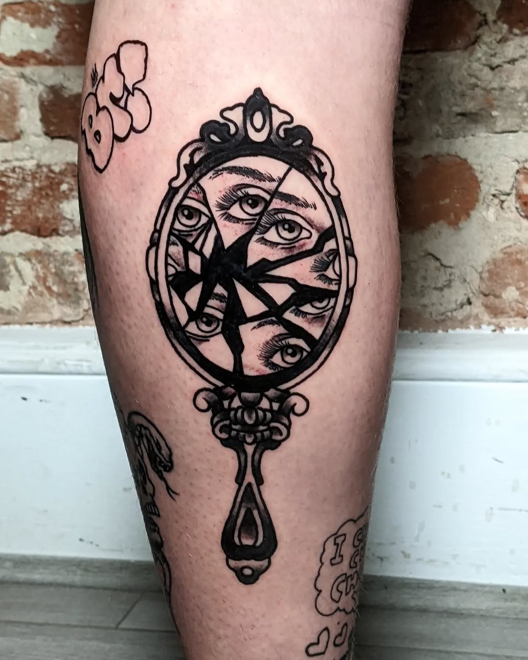 Unique cracked mirror tattoo with hidden eyes Tattoo Design