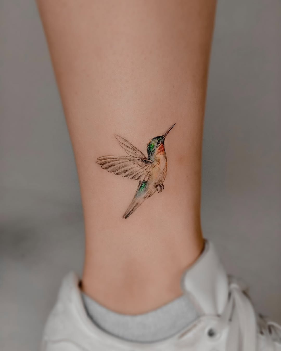 Vibrant hummingbird tattoo on ankle design Tattoo Design