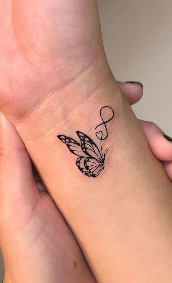 Fine Line Butterfly Wrist Tattoo with Infinity Heart, a tattoo design rendered in fine-line.
