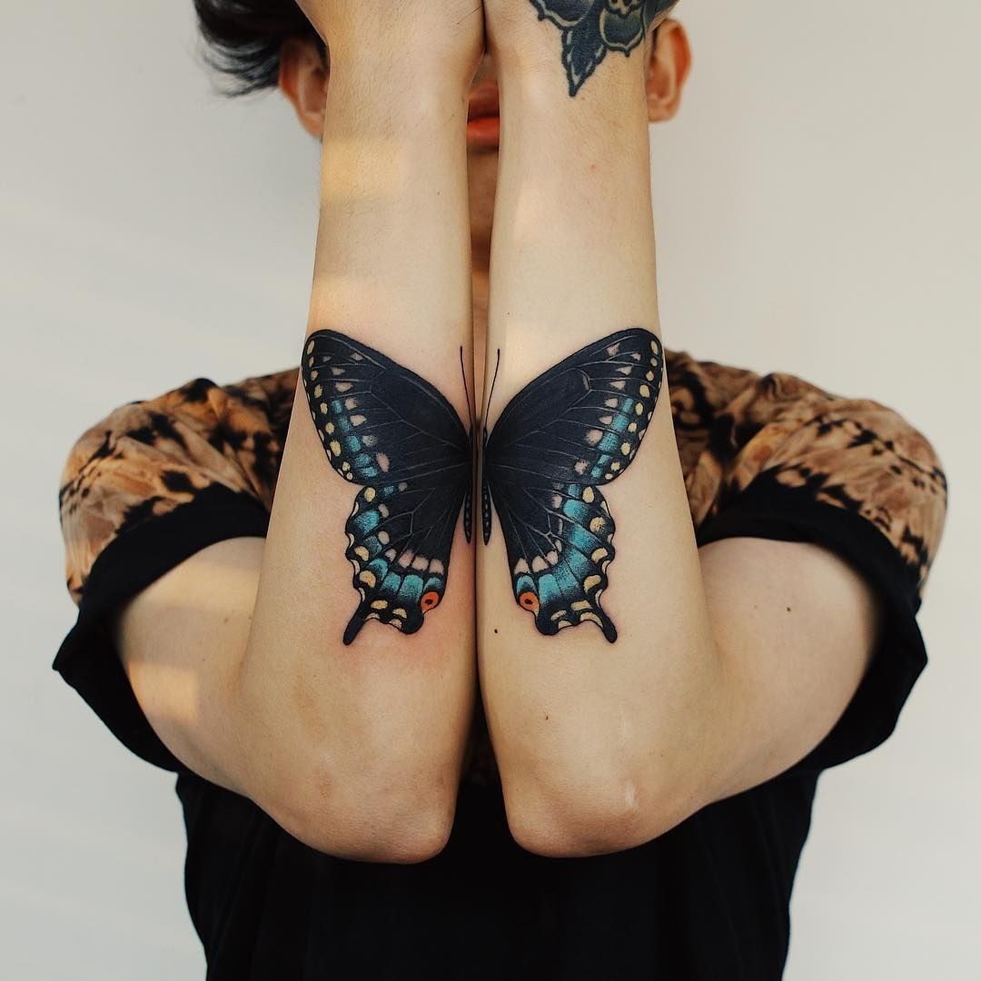 Matching Butterfly Wings on Both Arms, a tattoo design rendered in bold.