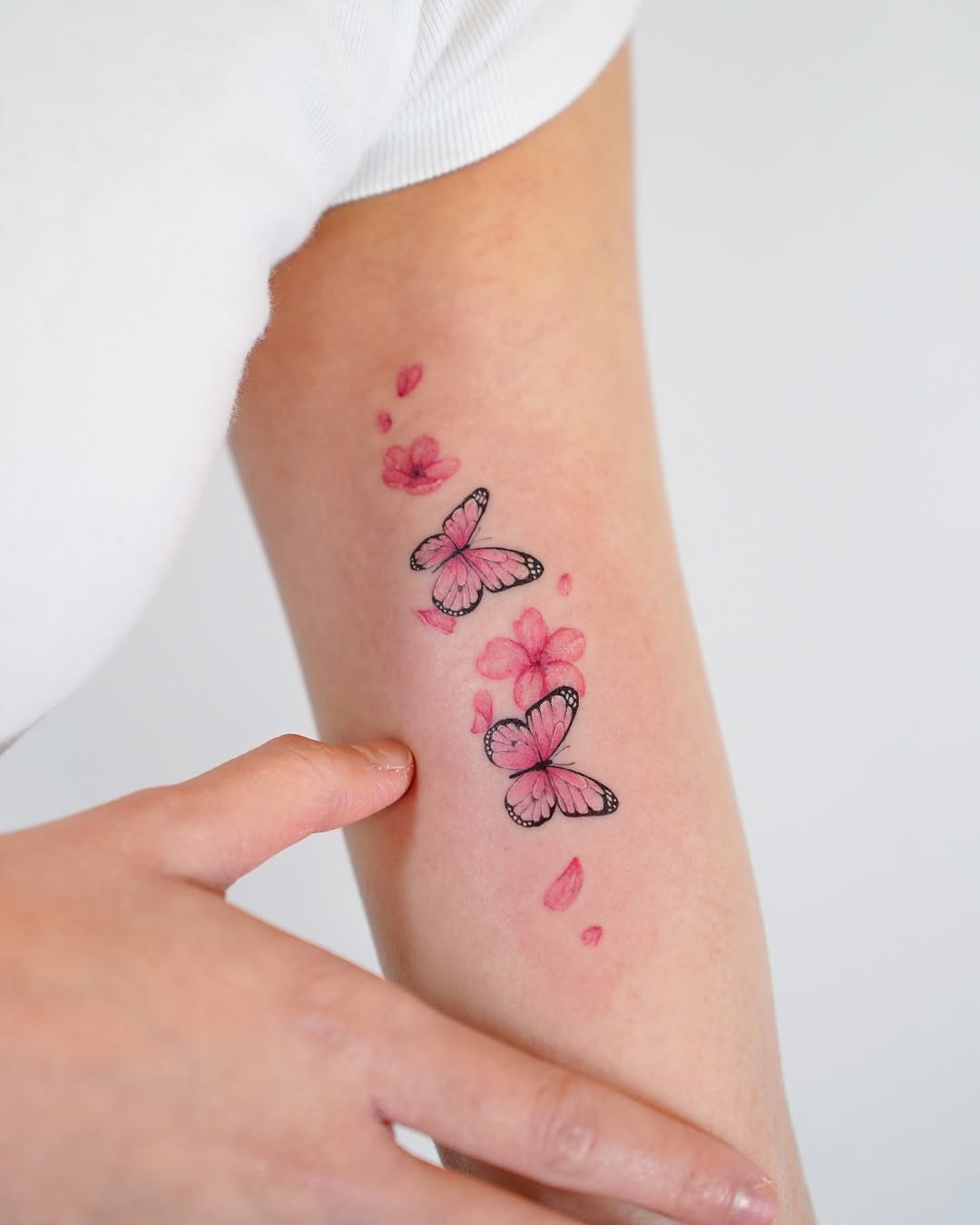 Delicate cherry blossoms with fluttering butterflies Tattoo Design