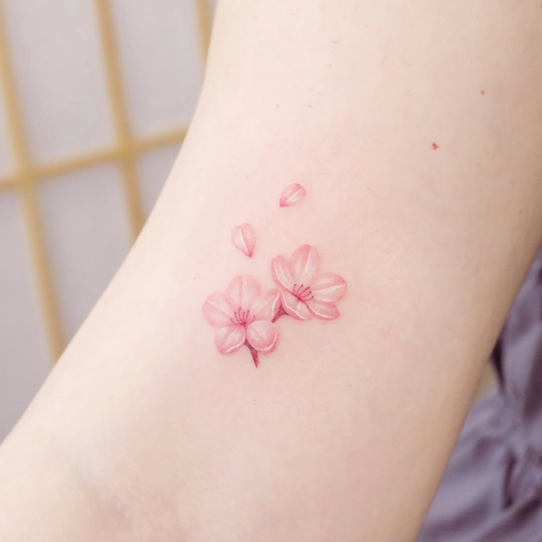 Elegant cherry blossom tattoo in soft pink hues Tattoo Design
