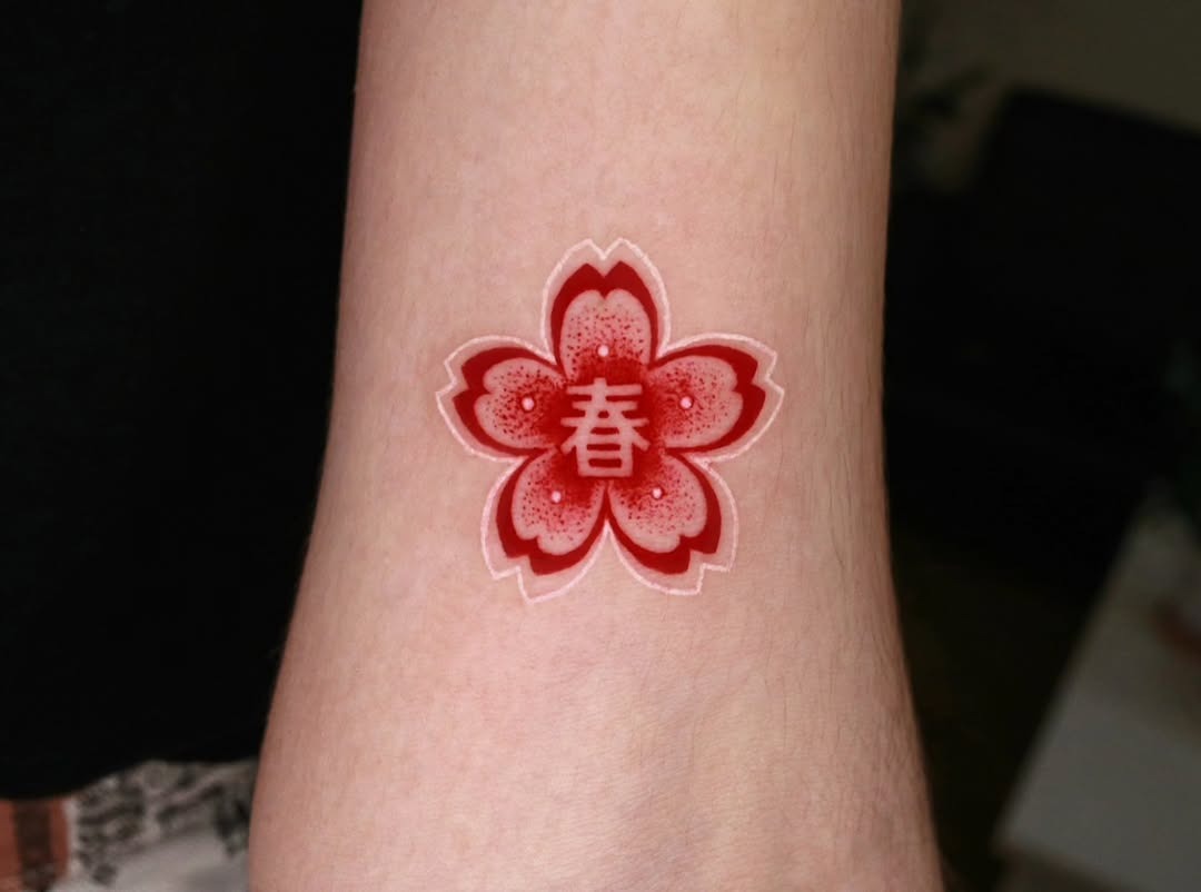 Vibrant red cherry blossom tattoo on wrist Tattoo Design