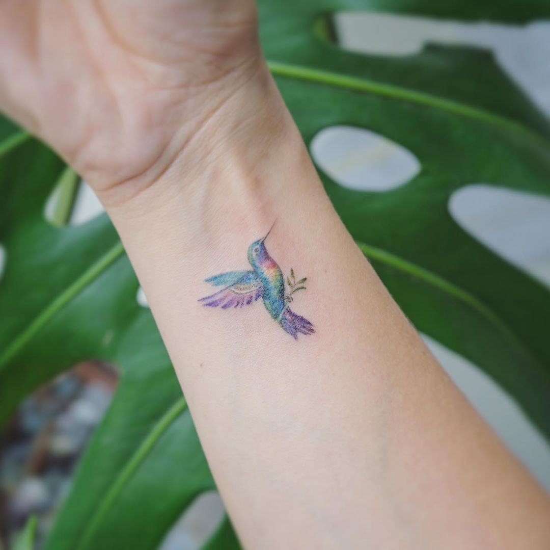 Pastel Small Hummingbird Tattoo Holding an Olive Branch Tattoo Design