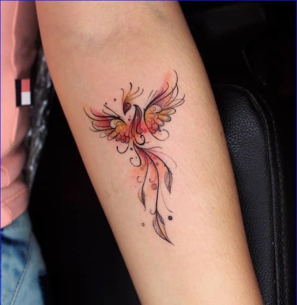 This tattoo showcases a graceful phoenix depicted in a stylized, flowing design with red and orange hues evoking the bird's fiery rebirth from ashes.