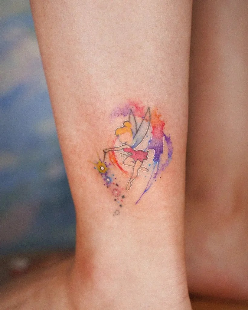 Capturing the whimsical spirit of a pixie, this tattoo merges the playful imagery of a small, cute fairy with splashes of yellow and purple watercolors.