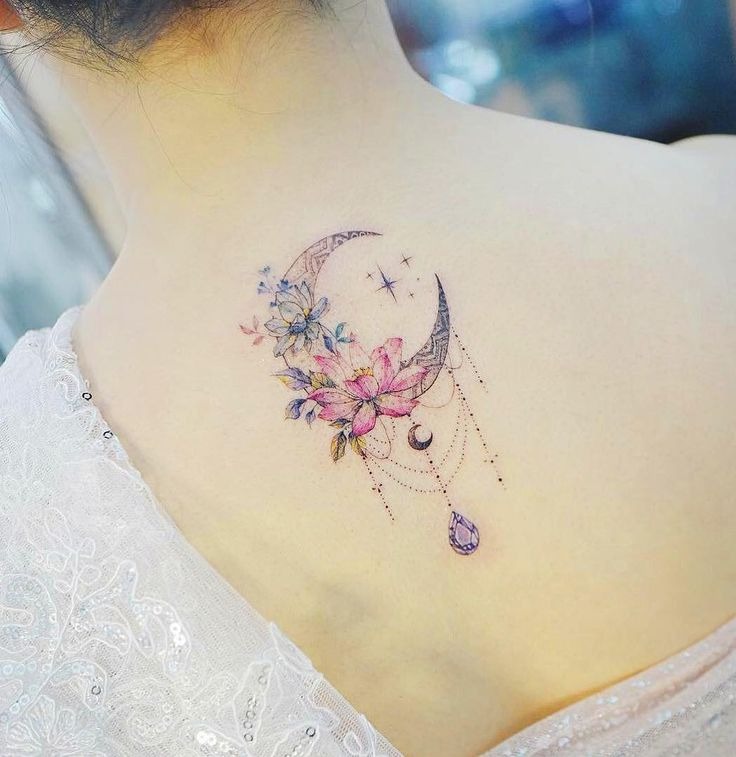 Intricate and subtle, this tattoo features a crescent moon adorned with delicate flowers and dangling jewels, creating a mystical and enchanting design.