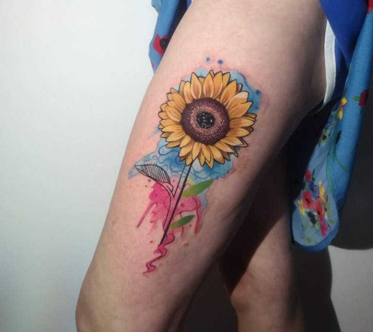 And full of life, this sunflower tattoo is dripping with rich yellows and blues, imbued with a splash of pink that seems to represent life's nectar.
