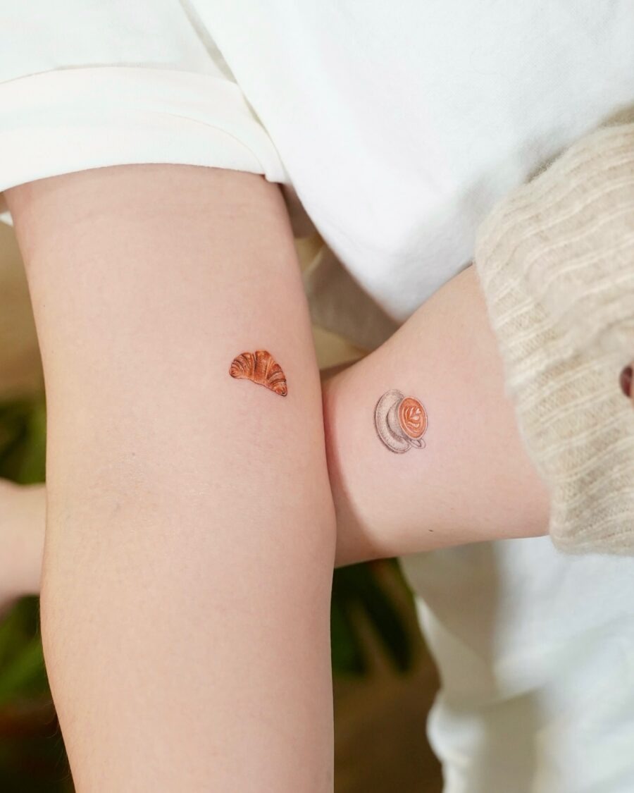 This image features two delightful croissant tattoos on arms.
