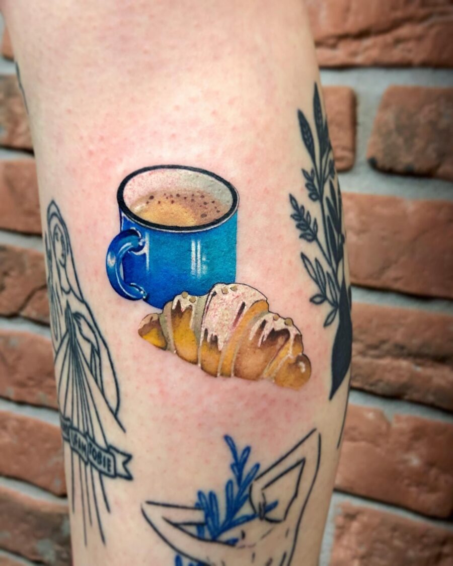 This tattoo features a delightful croissant beside a coffee pour-over.