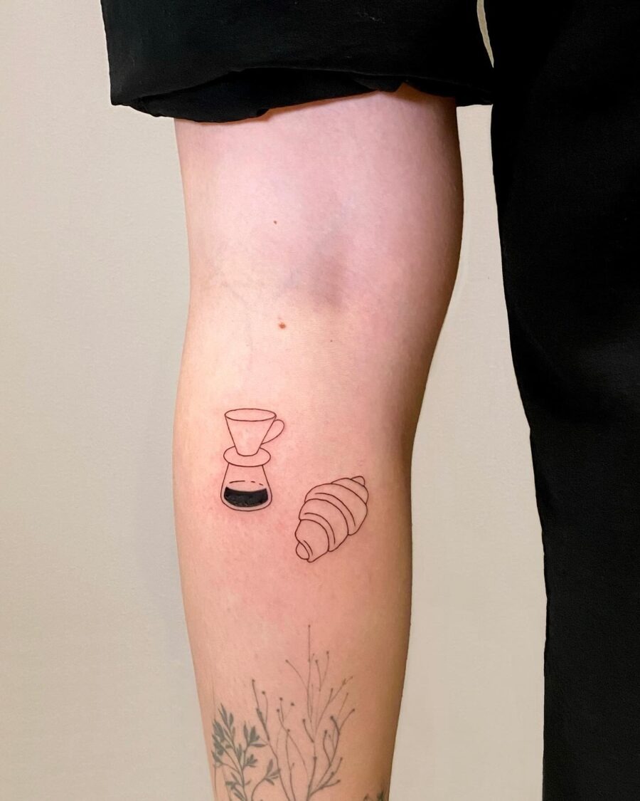 This tattoo features a delightful croissant beside a coffee pour-over.