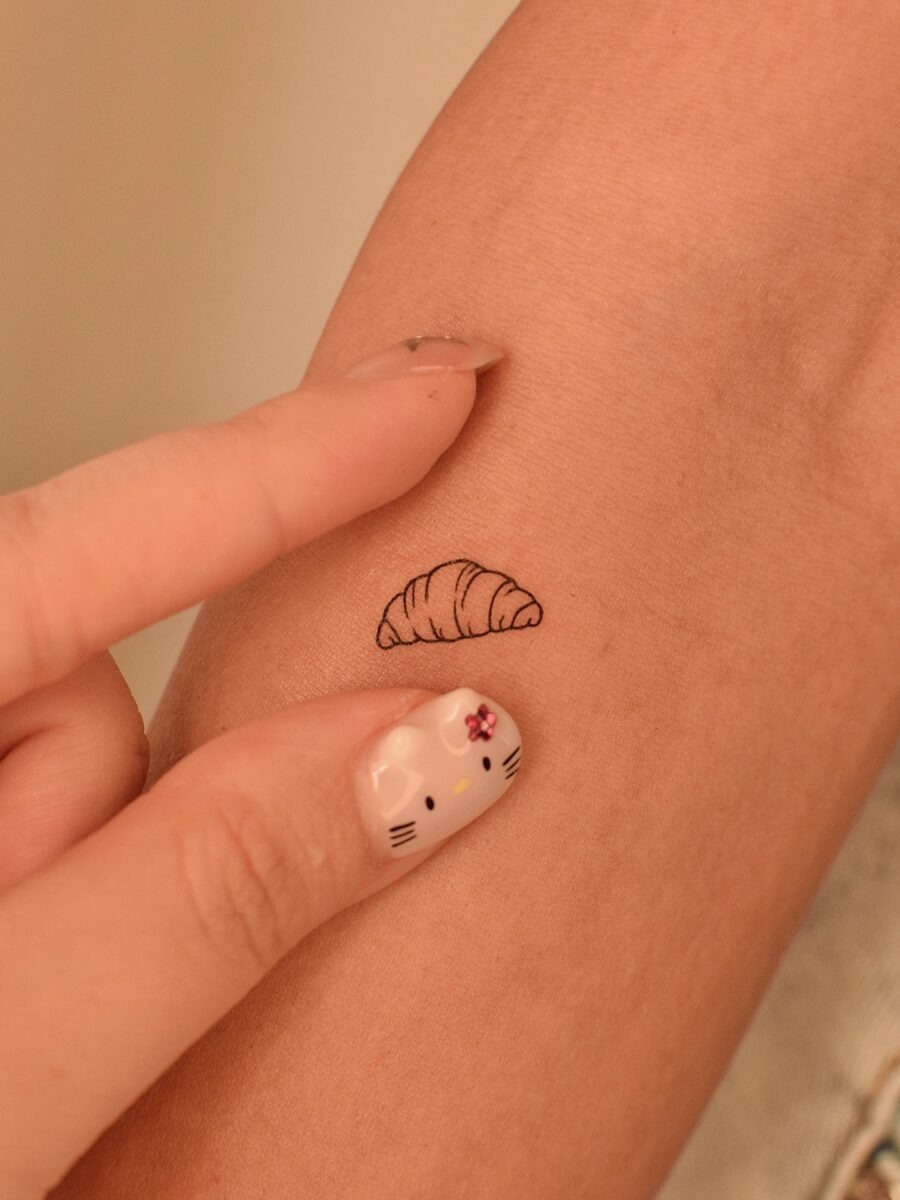 This small croissant tattoo adds a delightful, playful vibe.