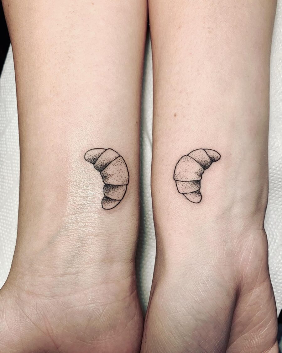 These croissant tattoos feature a minimalist black ink design that captures the essence of this beloved pastry.