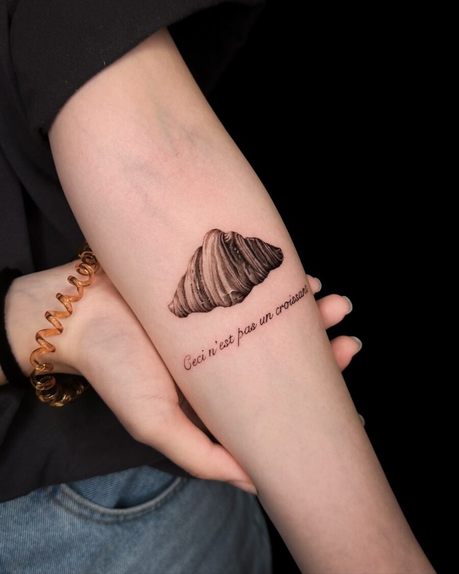 This eye-catching croissant tattoo features a beautifully detailed design, showing the layers and textures of the pastry.