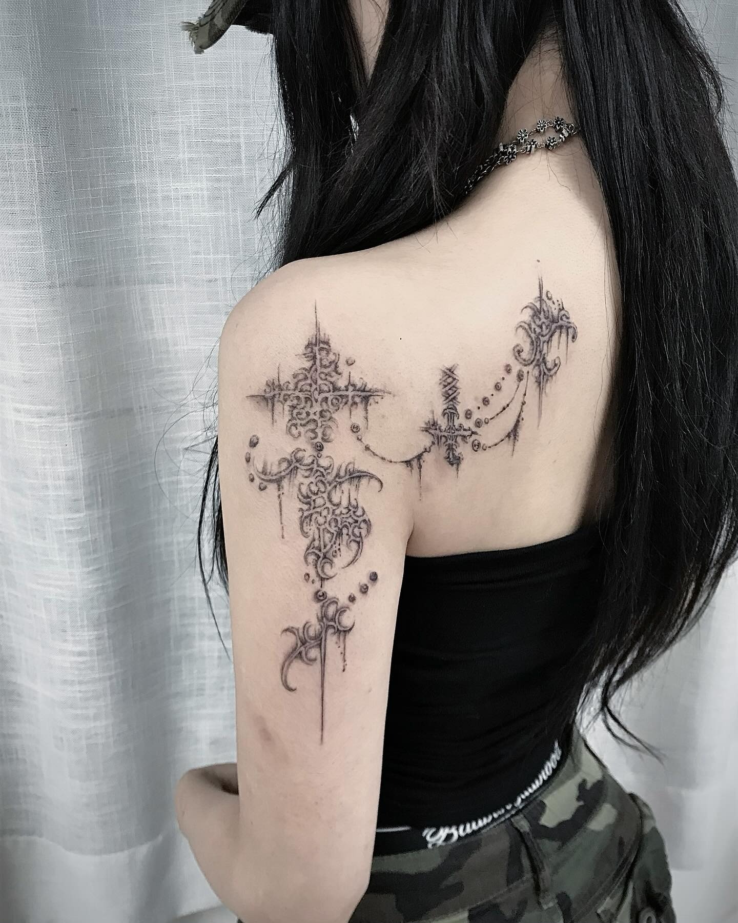 Gothic cross cybersigilism tattoo with suspended iron link chains and pointed spikes