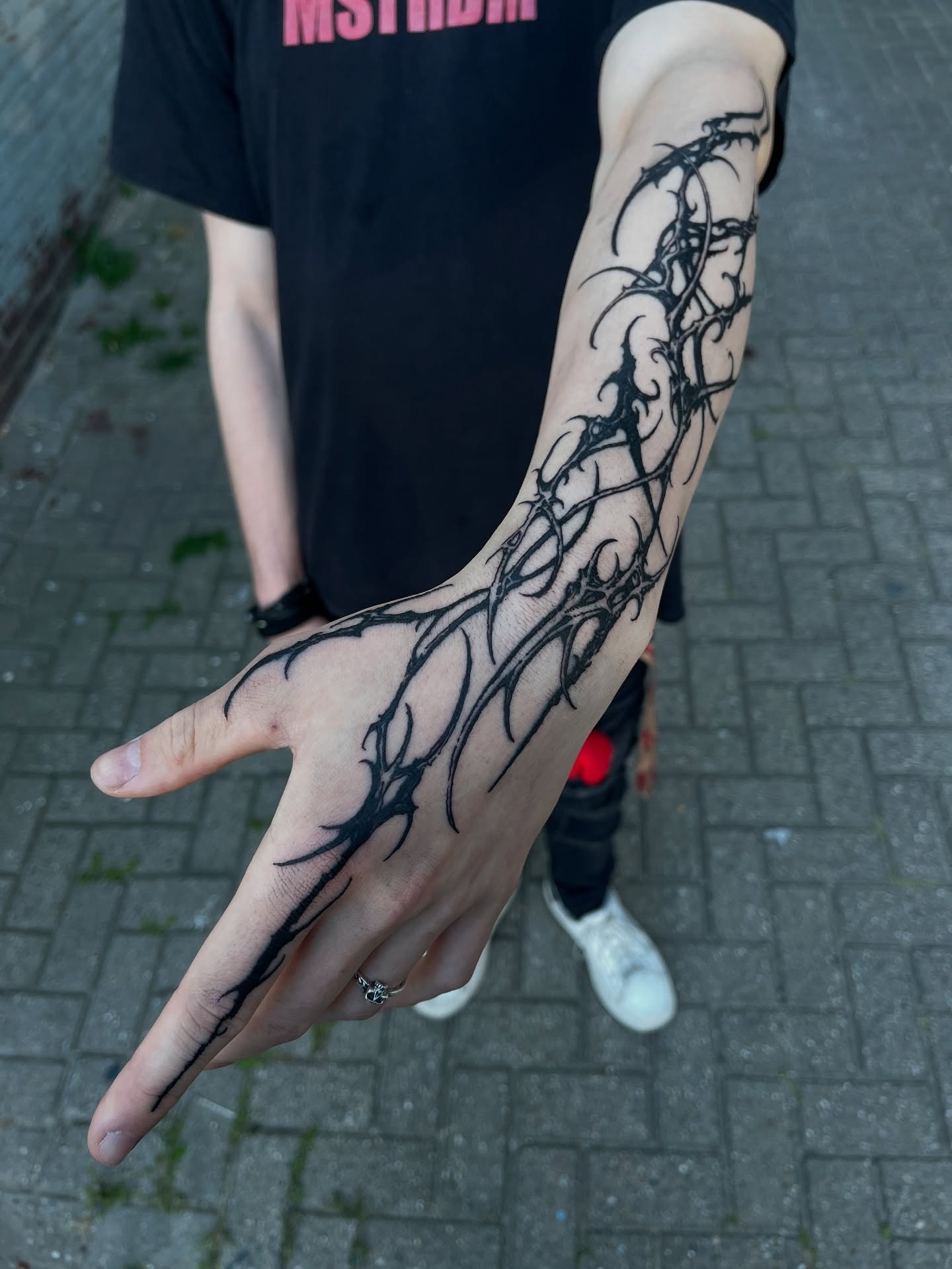 Dramatic full arm sleeve tattoo featuring continuous cybersigilism thorn patterns and circuits