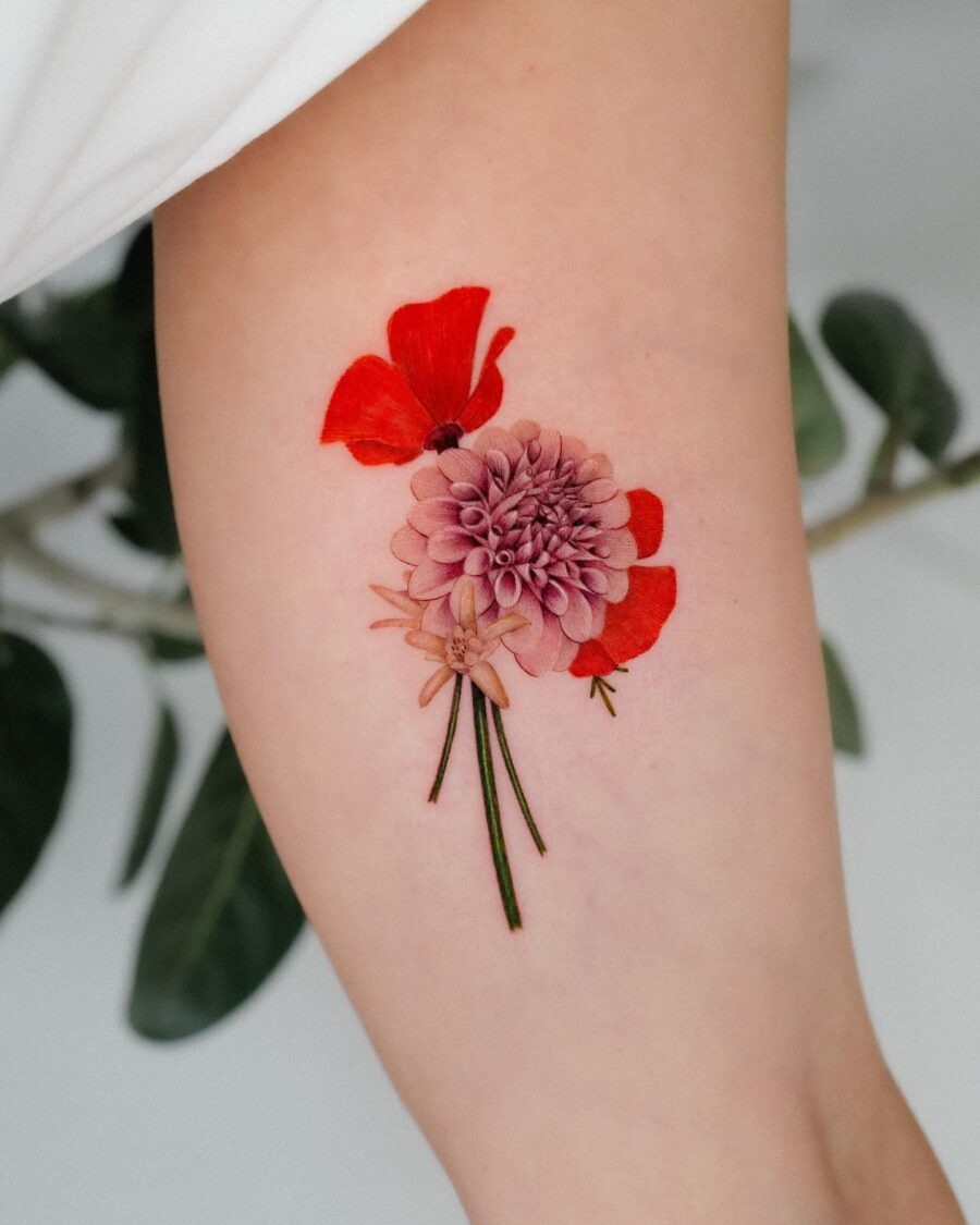 This tattoo showcases a dahlia paired with bold red poppy petals, exuding a lively, artistic charm.