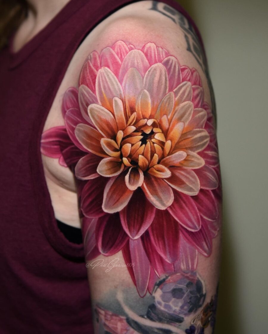 This dahlia tattoo showcases an intricate bloom with colors and detailed shading.