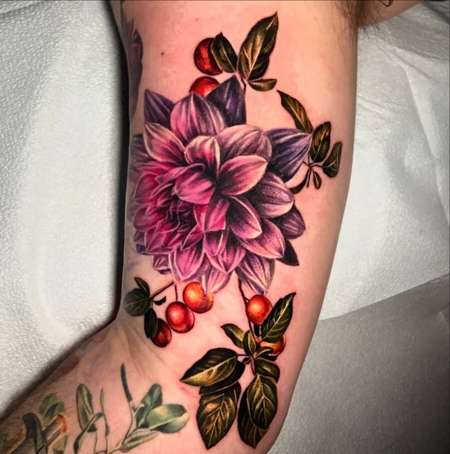 This dahlia tattoo features intricate details and a color palette.