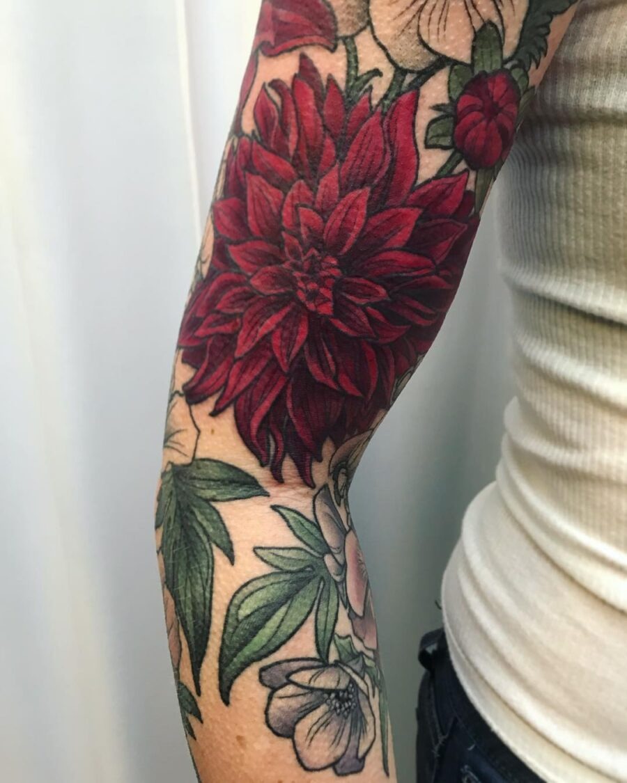 This dahlia tattoo showcases striking red petals that pop against the skin, enhancing the natural beauty of floral designs.