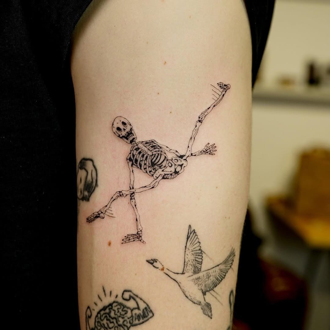 Expressive skeleton tattoo showcasing playful movement Tattoo Design