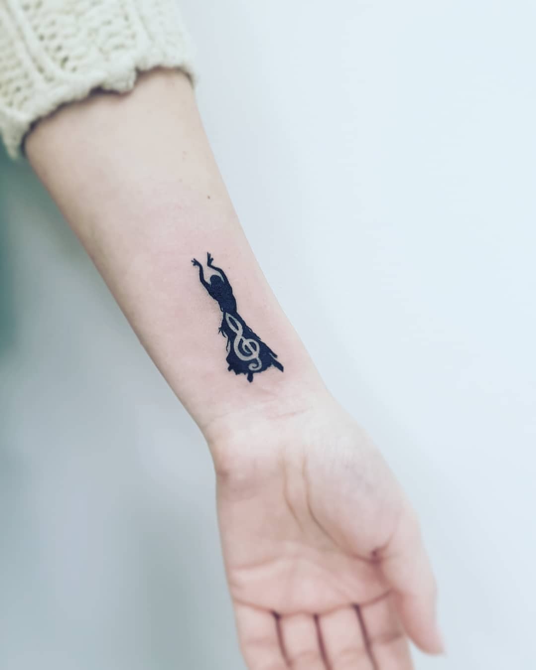 Graceful dancer intertwined with musical notes Tattoo Design
