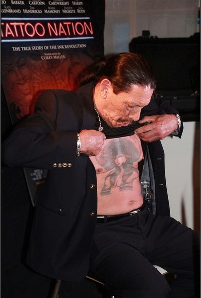 At a formal event, Trejo lifts his shirt to reveal his chest tattoo, proving that his ink remains as legendary as ever.