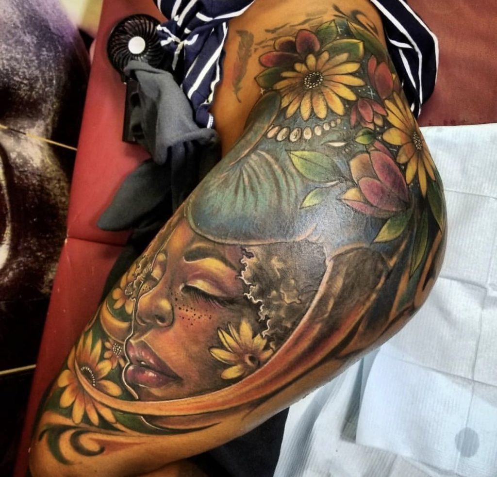 Afrocentric Portrait with Florals on the Thigh Tattoo Design