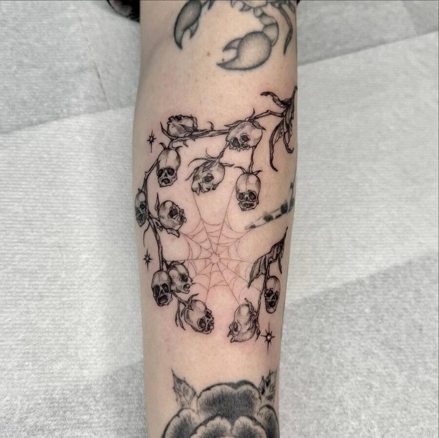 Intricate skulls entwined with delicate blooms Tattoo Design