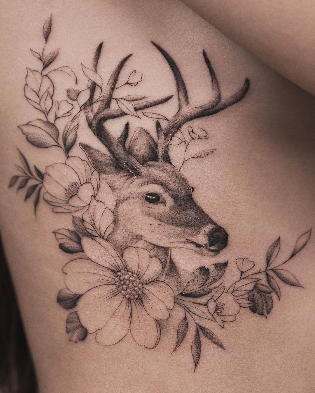 Fine Line Deer with Large Blossoms, a tattoo design rendered in delicate fine-line for the arm.