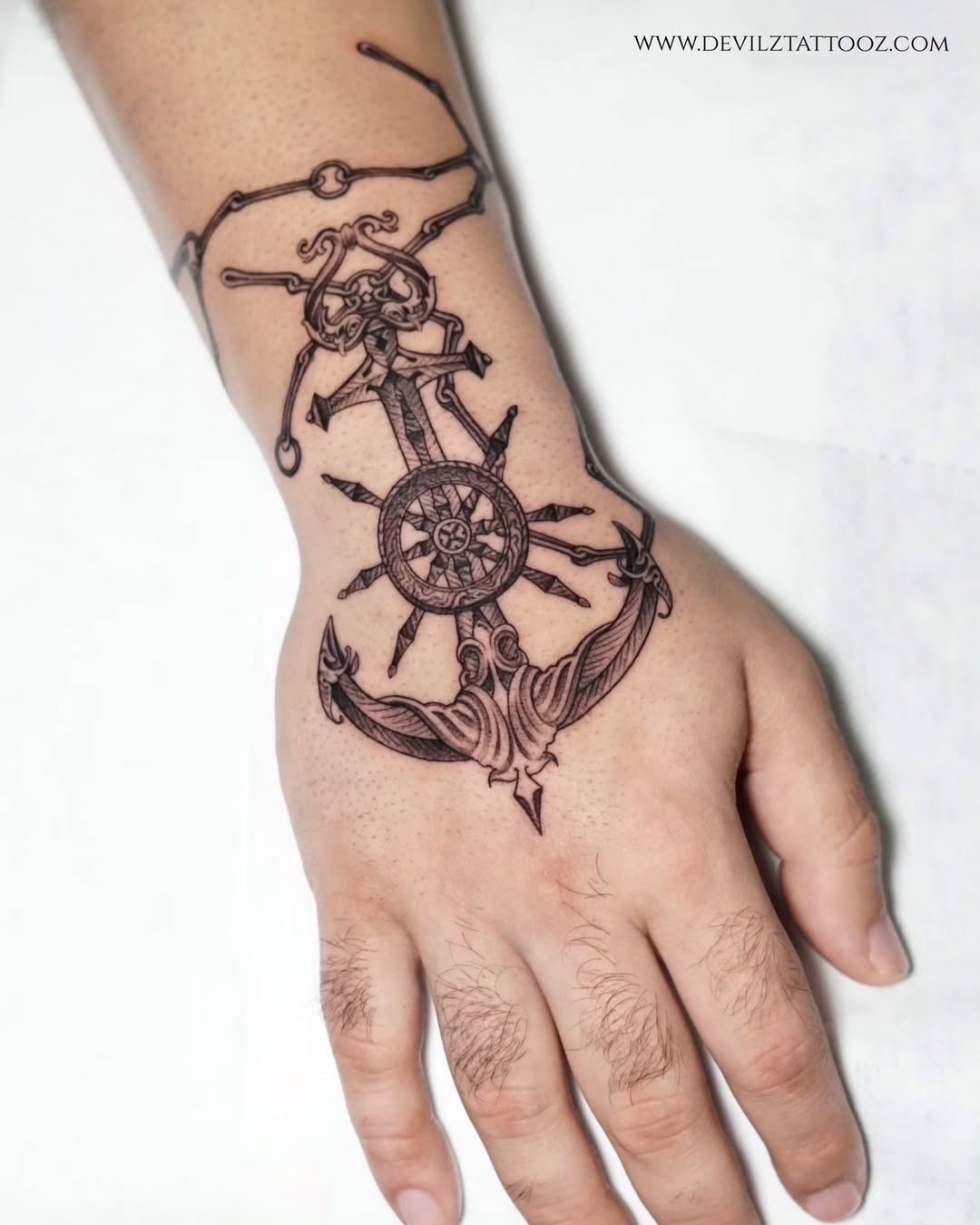 Intricate anchor tattoo with skull and ship wheel Tattoo Design